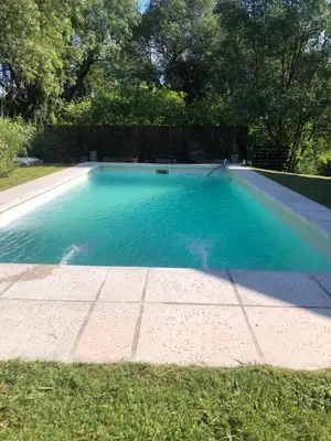 a swimming pool with blue water in a yard at Altos de Lagunitas in Villa General Belgrano