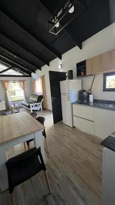 a kitchen and dining room with a table and a refrigerator at Altos de Lagunitas in Villa General Belgrano