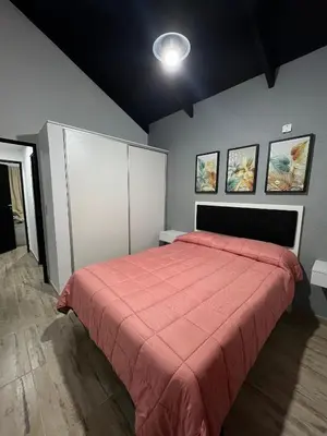 a bedroom with a bed with a red comforter at Altos de Lagunitas in Villa General Belgrano