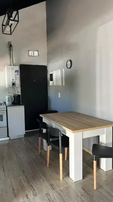 a table and chairs in a kitchen with a table and a clock at Altos de Lagunitas in Villa General Belgrano