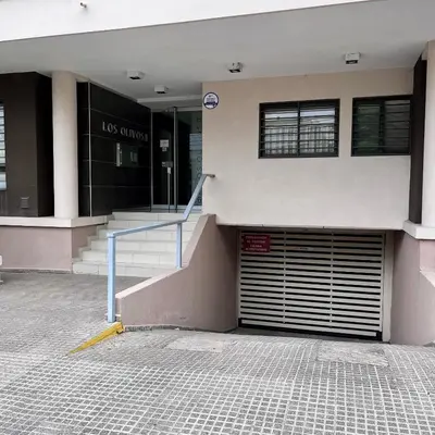 a building with a garage door in front of it at Departamento céntrico con cochera Muy cómodo cerca de todo in Villa Carlos Paz