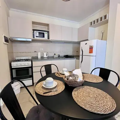 a kitchen with a table and chairs and a kitchen with a refrigerator at Departamento céntrico con cochera Muy cómodo cerca de todo in Villa Carlos Paz