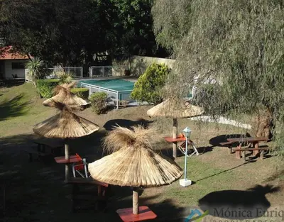 a group of straw umbrellas in front of a pool at Hosteria de los Césares in Merlo