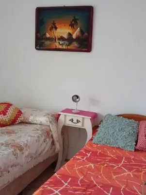 a bedroom with a bed and a table and a picture on the wall at La Casita del tano con Pileta in Villa Carlos Paz
