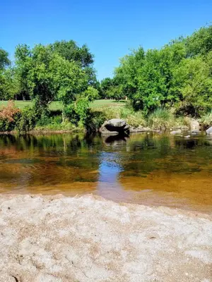 a river with a rock in the middle at La casa del Algarrobo in San Antonio de Arredondo