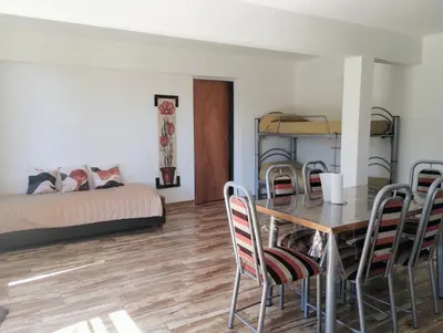 a room with a table and chairs and a bed at La casa del Algarrobo in San Antonio de Arredondo
