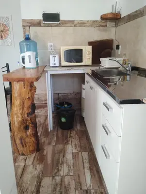 a small kitchen with a table and a microwave at La casa del Algarrobo in San Antonio de Arredondo