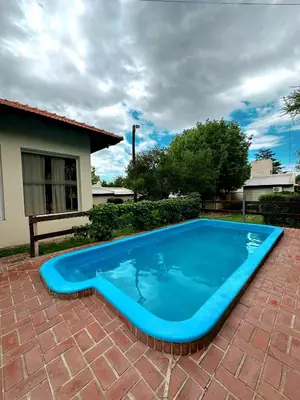 a large blue swimming pool on a brick patio at La Herradura in Mina Clavero