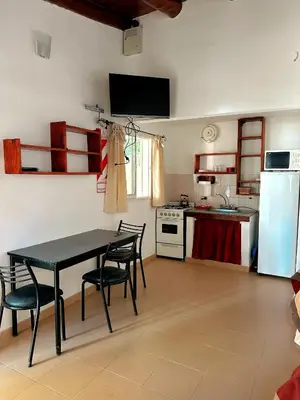 a kitchen with a table and chairs and a refrigerator at La Herradura in Mina Clavero