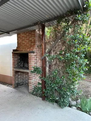 an outdoor brick oven with a metal roof at La Herradura in Mina Clavero