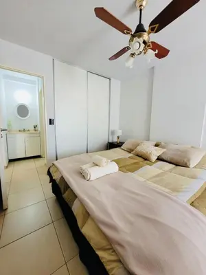 a bedroom with a large bed with a ceiling fan at Departamento premium con balcón, vista y atardeceres in Cordoba