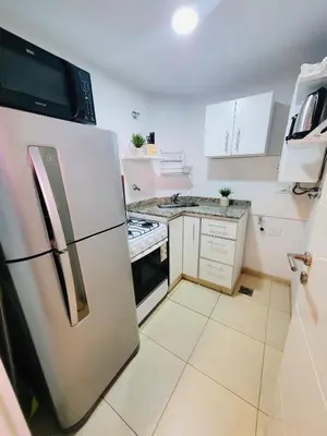 a kitchen with a refrigerator and a stove at Departamento premium con balcón, vista y atardeceres in Cordoba