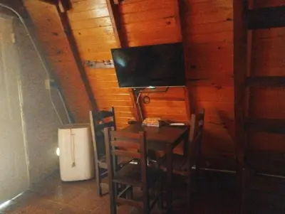 a room with a table with chairs and a television at Altos del torreón in Villa Rumipal