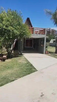 a house with a tree in front of a driveway at Altos del torreón in Villa Rumipal