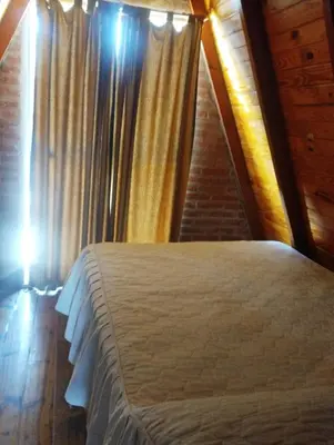 a bedroom with a bed and a staircase with curtains at Altos del torreón in Villa Rumipal