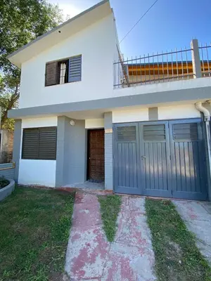 a house with blue garage doors in front of it at casita Playas de oro in Villa Carlos Paz