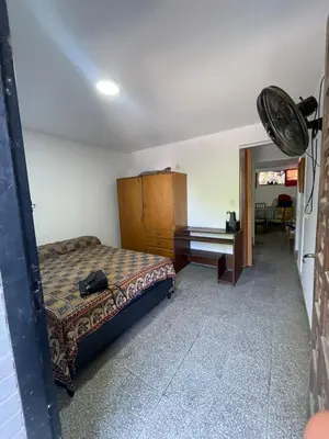 a bedroom with a bed and a dresser and a piano at casita Playas de oro in Villa Carlos Paz