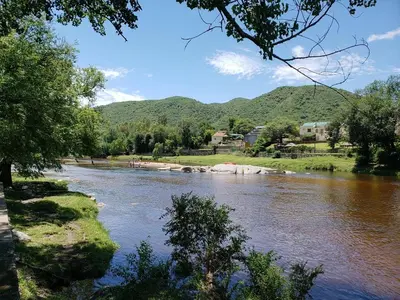a view of a river with mountains in the background at casita Playas de oro in Villa Carlos Paz