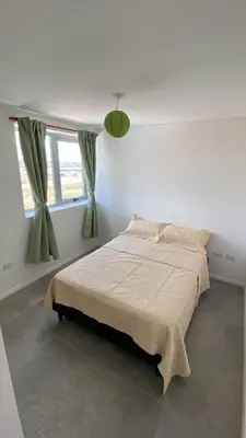 a white bedroom with a bed and a window at Departamento 1 dor ciudad gama seguridad 24h pileta calidad in Cordoba