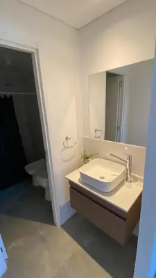 a bathroom with a sink and a toilet and a mirror at Departamento 1 dor ciudad gama seguridad 24h pileta calidad in Cordoba