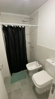 a bathroom with a toilet and a black shower curtain at Departamento 1 dor ciudad gama seguridad 24h pileta calidad in Cordoba