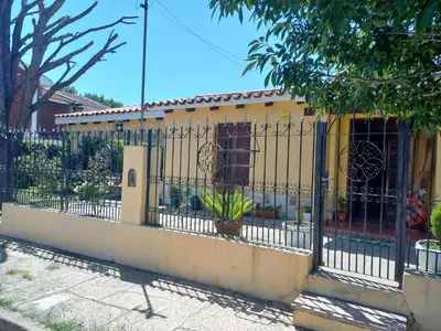 a fence in front of a yellow building at Malvinas Departamento in Villa Carlos Paz