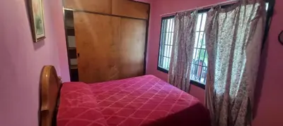 a pink bedroom with a bed and a window at Malvinas Departamento in Villa Carlos Paz