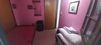 a room with a room with pink walls and a couch at Malvinas Departamento in Villa Carlos Paz