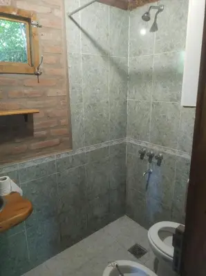 a bathroom with a shower and a toilet at Cabañas L' armonie in Bialet Massé