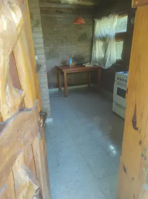 an open door to a kitchen with a table at Cabañas L' armonie in Bialet Massé