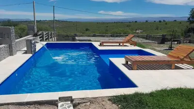 a swimming pool with a table and a bench at Rincon de Bialet in Bialet Massé