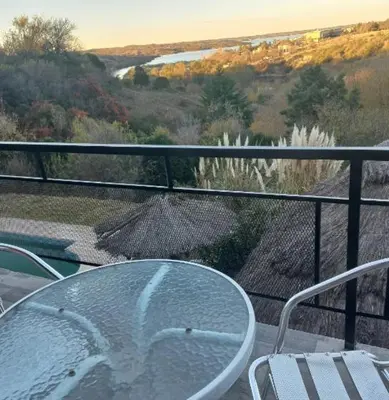 a glass table and chairs on a balcony at Posada Miralejos in Trapiche