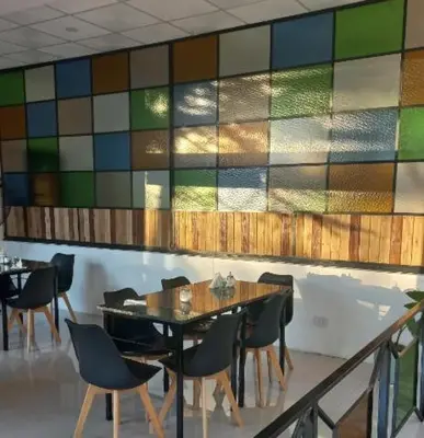 a dining room with a table and chairs and a mosaic wall at Posada Miralejos in Trapiche