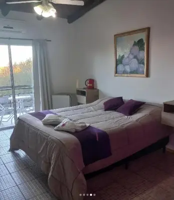a bedroom with a large bed with a painting on the wall at Posada Miralejos in Trapiche