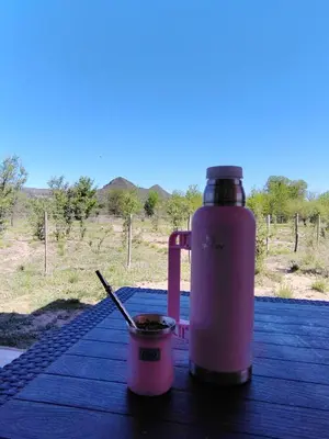 a pink water bottle and a cup on a table at Cabaña Valle del alma in Nono