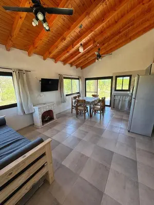 a living room with a table and a fireplace at Cabaña Valle del alma in Nono