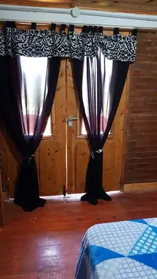 two black curtains in a room with a window at La Fortaleza in Villa Parque Siquiman