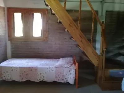a room with a bed and a staircase with a window at La Fortaleza in Villa Parque Siquiman