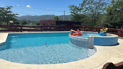 a swimming pool with two children playing in the water at La Fortaleza in Villa Parque Siquiman