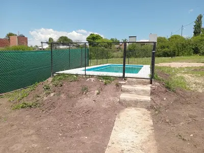 a fence around a swimming pool in a field at Dulce Azul in Villa García