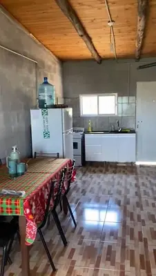 a kitchen with a table and a refrigerator at Dulce Azul in Villa García
