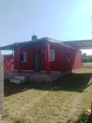 a red brick house with a red door at Dulce Azul in Villa García