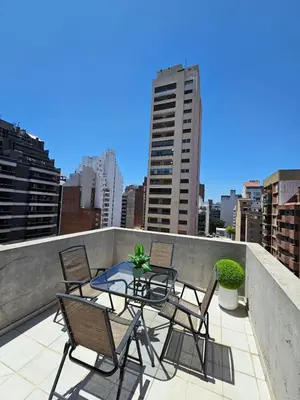 a patio with a table and chairs on a balcony at Moderno departamento con terraza privada in Cordoba