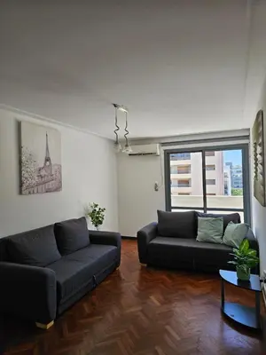 a living room with two couches and a large window at Moderno departamento con terraza privada in Cordoba