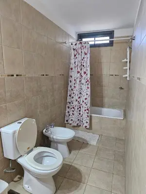 a bathroom with a toilet and a shower curtain at Moderno departamento con terraza privada in Cordoba