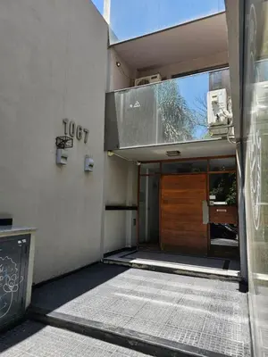 an entrance to a building with a wooden door at Moderno departamento con terraza privada in Cordoba