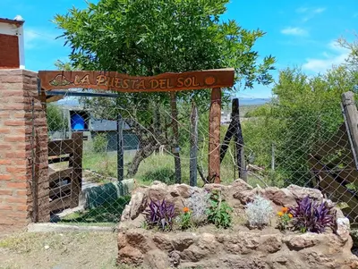 a sign that says la kissed del sol in front of a fence at Cabañas La Puesta del Sol in Estancia Vieja