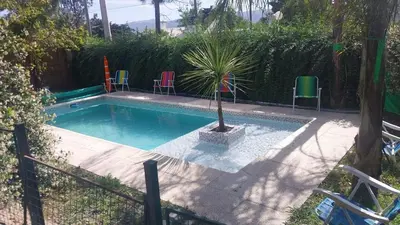 a swimming pool with a palm tree in a yard at La casa accesible y perfecta para tus vacaciones in Villa Santa Cruz del Lago