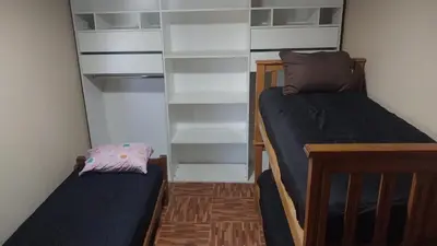 a small room with two beds and shelves at La casa accesible y perfecta para tus vacaciones in Villa Santa Cruz del Lago