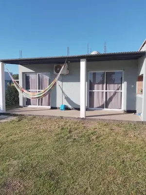 a house with a hammock in front of it at Sol y Calma in Villa Rumipal